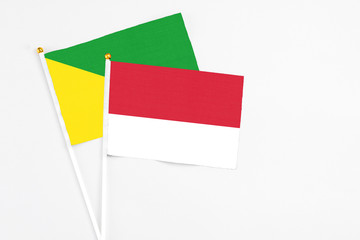 Monaco and French Guiana stick flags on white background. High quality fabric, miniature national flag. Peaceful global concept.White floor for copy space.