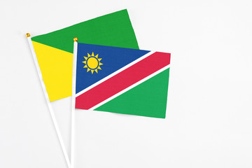 Namibia and French Guiana stick flags on white background. High quality fabric, miniature national flag. Peaceful global concept.White floor for copy space.