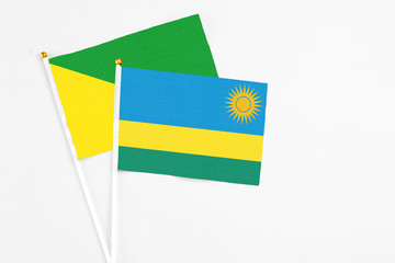 Rwanda and French Guiana stick flags on white background. High quality fabric, miniature national flag. Peaceful global concept.White floor for copy space.
