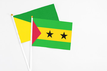 Sao Tome And Principe and French Guiana stick flags on white background. High quality fabric, miniature national flag. Peaceful global concept.White floor for copy space.