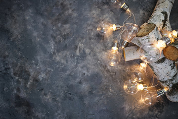 Christmas background with wood tree and decor. Top view with copy space and lighting bulb