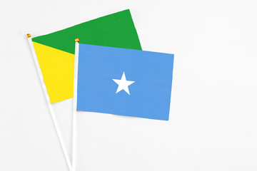 Somalia and French Guiana stick flags on white background. High quality fabric, miniature national flag. Peaceful global concept.White floor for copy space.