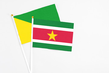 Suriname and French Guiana stick flags on white background. High quality fabric, miniature national flag. Peaceful global concept.White floor for copy space.
