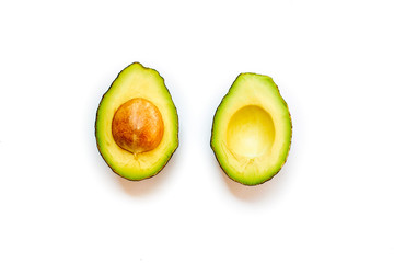 Top view of the Half of the avocado and the seeds in the middle isolate on white background. Green fruit is a healthy food.