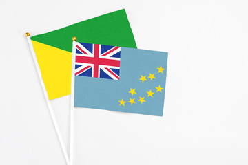 Tuvalu and French Guiana stick flags on white background. High quality fabric, miniature national flag. Peaceful global concept.White floor for copy space.