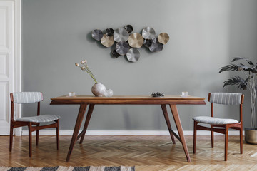 Modern and stylish dining room interior with glamour wooden table , elegant chairs and design...