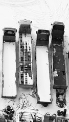 Truck under the snow. lorry covered with snow after snowfall. long trucks stand in a row aerial view. transportation concept. snow covered vehicles. copy space