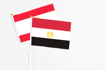 Egypt and French Polynesia stick flags on white background. High quality fabric, miniature national flag. Peaceful global concept.White floor for copy space.