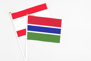 Gambia and French Polynesia stick flags on white background. High quality fabric, miniature national flag. Peaceful global concept.White floor for copy space.