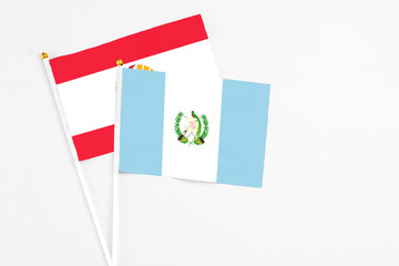 Guatemala and French Polynesia stick flags on white background. High quality fabric, miniature national flag. Peaceful global concept.White floor for copy space.