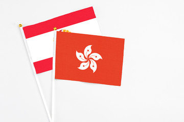 Hong Kong and French Polynesia stick flags on white background. High quality fabric, miniature national flag. Peaceful global concept.White floor for copy space.