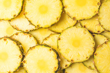 Pineapple juicy yellow slices background. Top view.