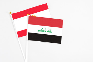 Iraq and French Polynesia stick flags on white background. High quality fabric, miniature national flag. Peaceful global concept.White floor for copy space.