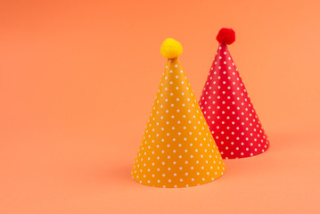 Colorful birthday caps on orange background.