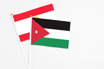Jordan and French Polynesia stick flags on white background. High quality fabric, miniature national flag. Peaceful global concept.White floor for copy space.