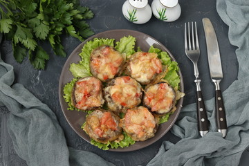 Baked champignons stuffed with tomatoes under suluguni cheese, a festive hot snack of Georgian cuisine