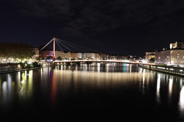 Fototapeta na wymiar La passerelle du palais de justice sur la rivière Saône dans la ville de Lyon - Vue de nuit - Département du Rhône - France 
