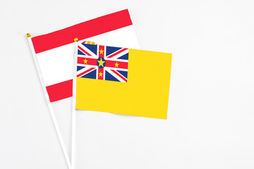 Niue and French Polynesia stick flags on white background. High quality fabric, miniature national flag. Peaceful global concept.White floor for copy space.