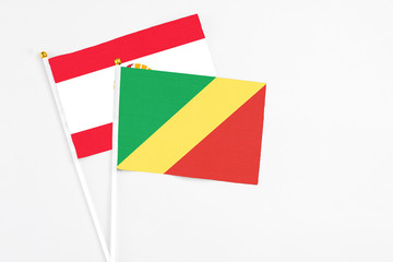 Republic Of The Congo and French Polynesia stick flags on white background. High quality fabric, miniature national flag. Peaceful global concept.White floor for copy space.