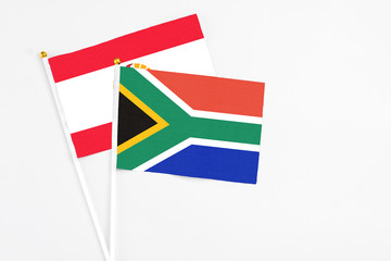 South Africa and French Polynesia stick flags on white background. High quality fabric, miniature national flag. Peaceful global concept.White floor for copy space.