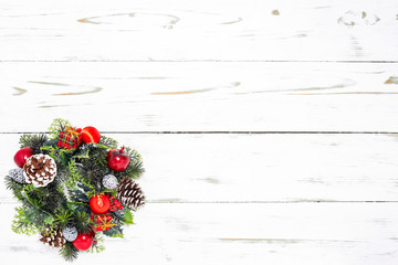 Fototapeta na wymiar Ein Weihnachtskranz aus Weihnachtsdekoration und Tannenzweige auf einem Weißen Holz Hintergrund