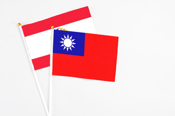 Taiwan and French Polynesia stick flags on white background. High quality fabric, miniature national flag. Peaceful global concept.White floor for copy space.