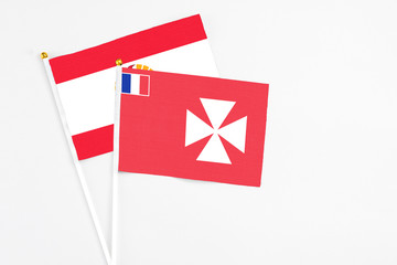 Wallis And Futuna and French Polynesia stick flags on white background. High quality fabric, miniature national flag. Peaceful global concept.White floor for copy space.