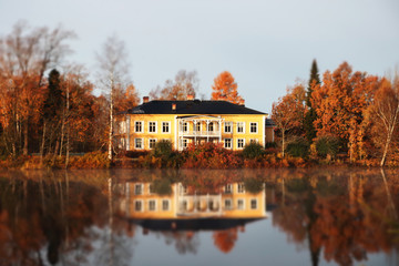 Fototapeta premium Kouvola, Finland - 15 October 2019: Autumn landscape with beautiful wooden Rabbelugn Manor - Takamaan Kartano. Wrede family house was built in 1820 on the river Kymijoki bank.