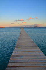 Obraz premium Wooden pier going to sea at sunset.