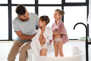 Young father with little daughters in bathroom