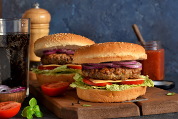 Homemade hamburger with beef, cheese and sauce on a concrete background. Horizontal.