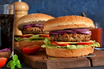 Homemade hamburger with beef, cheese and sauce on a concrete background. Horizontal.