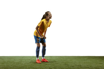 Young female soccer or football player with long hair in sportwear and boots training on white background. Concept of healthy lifestyle, professional sport, motion, movement. Upset, disappointed.