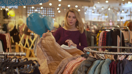 Girl quickly takes clothes off the hanger in the store