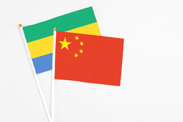 China and Gabon stick flags on white background. High quality fabric, miniature national flag....