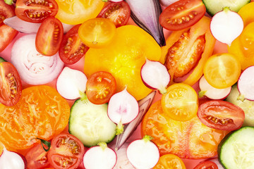 Bright colorful vegetables background. Salad ingredients close up, tomatoes cucumber peppers onions cut on white, top view, selective focus