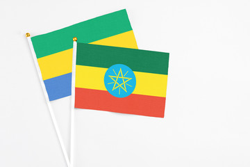 Ethiopia and Gabon stick flags on white background. High quality fabric, miniature national flag. Peaceful global concept.White floor for copy space.