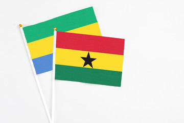Ghana and Gabon stick flags on white background. High quality fabric, miniature national flag. Peaceful global concept.White floor for copy space.