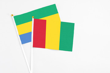 Guinea and Gabon stick flags on white background. High quality fabric, miniature national flag....
