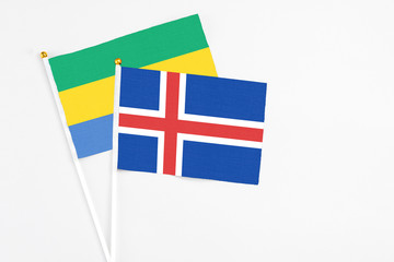 Iceland and Gabon stick flags on white background. High quality fabric, miniature national flag....