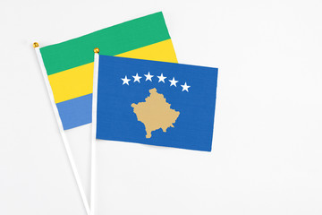 Kosovo and Gabon stick flags on white background. High quality fabric, miniature national flag....