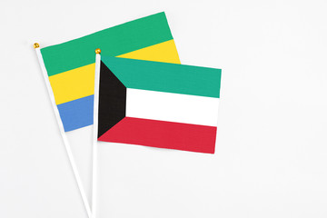 Kuwait and Gabon stick flags on white background. High quality fabric, miniature national flag. Peaceful global concept.White floor for copy space.