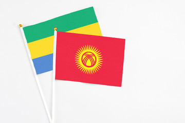 Kyrgyzstan and Gabon stick flags on white background. High quality fabric, miniature national flag....