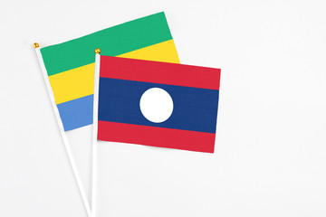 Laos and Gabon stick flags on white background. High quality fabric, miniature national flag....