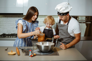 Beautiful family in the kitchen together preparing a pizza.