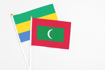 Maldives and Gabon stick flags on white background. High quality fabric, miniature national flag....