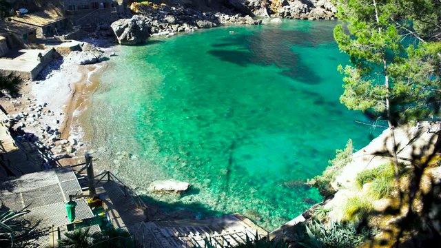 Top view of a beautiful beach with turquoise water and white sand, vacation and resort concept. Art. Breathtaking sea shore with bungalows and stony cottages.