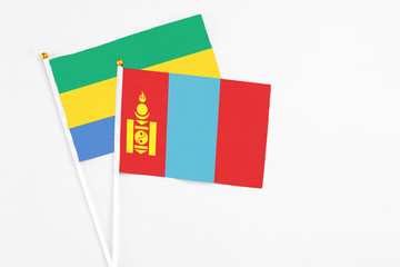 Mongolia and Gabon stick flags on white background. High quality fabric, miniature national flag. Peaceful global concept.White floor for copy space.