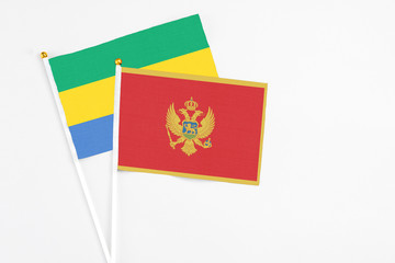 Montenegro and Gabon stick flags on white background. High quality fabric, miniature national flag. Peaceful global concept.White floor for copy space.