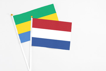 Netherlands and Gabon stick flags on white background. High quality fabric, miniature national...
